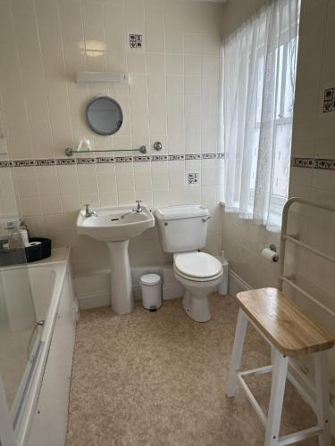 a white bathroom with a toilet and a sink at Lord Nelson Hotel in Bridport