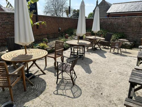 a group of tables and chairs with white umbrellas at Lord Nelson Hotel in Bridport
