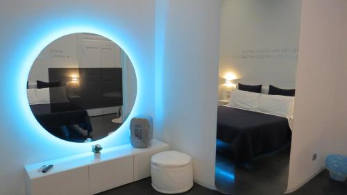 ナポリにあるスカイハウス キアタモネの鏡付きのベッドルーム1室、ベッド1台が備わるベッドルーム1室を提供しています。
