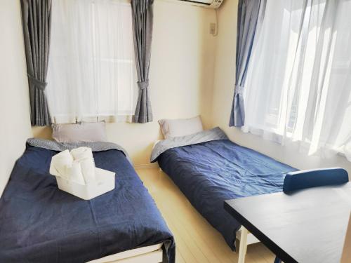 two beds in a room with a desk and a table at OHANA TOKYO HOUSE - Vacation STAY 67721v in Tokyo