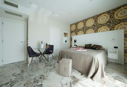 a bedroom with a bed and a table and chairs at Hotel Manuela in Varcaturo