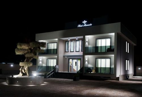 a building with a tree in front of it at night at Hotel Manuela in Varcaturo