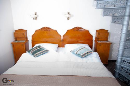 a bedroom with a bed with two pillows at Zagroda Kołodzieja in Zgorzelec