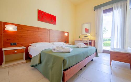 a bedroom with a large bed with a wooden headboard at Delle Rose Horses Club in Torre Vado