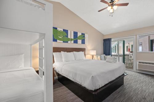 a bedroom with a bed and a ceiling fan at Sandpiper Beacon Beach Resort in Panama City Beach