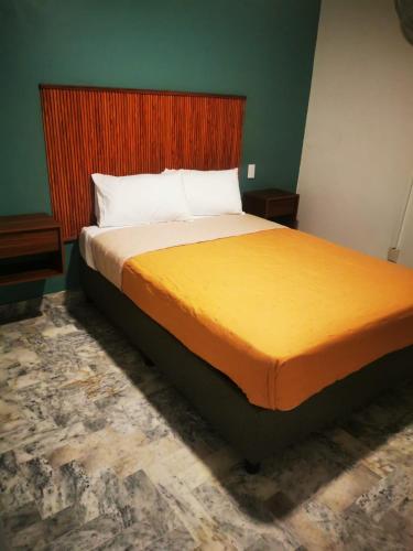 a bedroom with a large bed with a wooden headboard at Estancia Monraz in Guadalajara