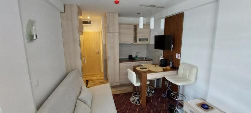 a small apartment with a table and a couch at Vila Zvončica, apartman Puzović 22 in Kopaonik