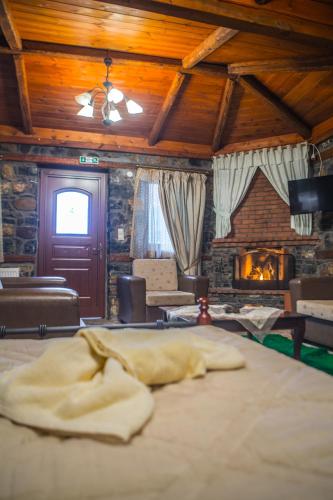 a living room with a bed and a fireplace at Ξενώνας Σκαλοπάτια in Palaios Agios Athanasios