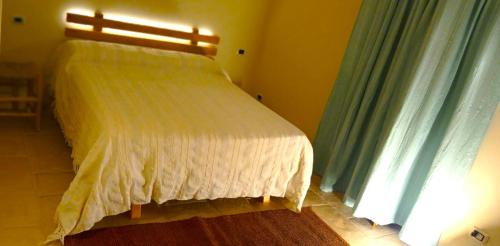 a bedroom with a white bed with a window at Massì bnb in Locorotondo