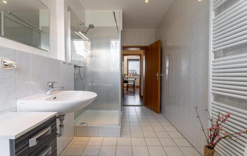 a white bathroom with a sink and a shower at Ostseebad-Karlshagen-grosszuegige-Ferienwohnung-Sommer in Ostseebad Karlshagen
