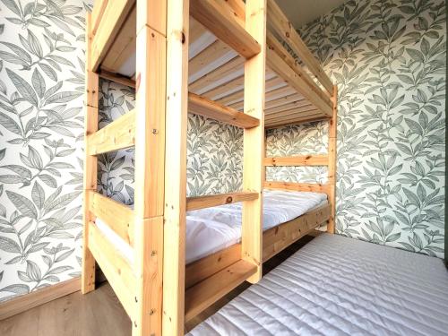 Letto a castello in legno in una camera con parete di Villa d'expection, 10 personnes avec piscine intérieure a La Combe-de-Lancey