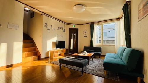 a living room with a blue couch and a chair at SecondHouse - Vacation STAY 53859v in Otaru