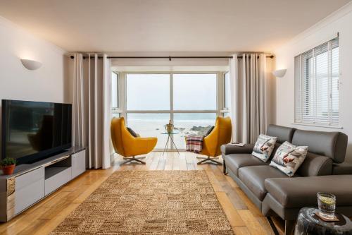 a living room with a couch and a television at Carbis Bay and Spa Hotel in St Ives
