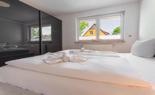 a bedroom with a white bed with two babies on it at Bernsteinbad-Koserow-Haus-Fuenf-Elemente-Ferienwohnung-Erde in Ostseebad Koserow