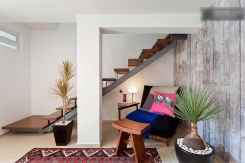a living room with a bed and a staircase at Duplex Penthouse Zona Rosa in Mexico City