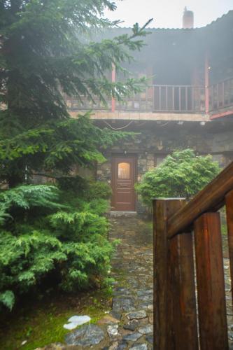 a gate in a japanese garden with a house at Ξενώνας Σκαλοπάτια in Palaios Agios Athanasios