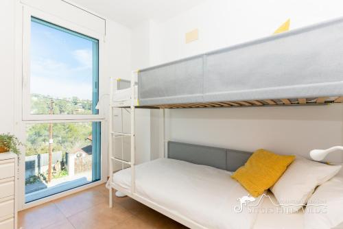 a bedroom with a bunk bed and a window at Villa Senia, close to Sitges with private pool in Olivella