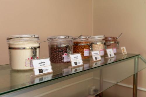 a glass shelf with jars of food on it at Rede Andrade Riviera Premium in Salvador