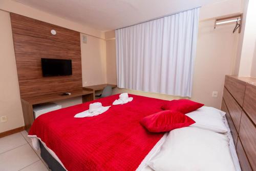 a bedroom with a red bed with red pillows at Rede Andrade Riviera Premium in Salvador