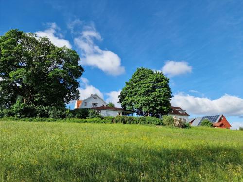 a field with trees and a house on a hill at Stuga i Småland in Kulltorp