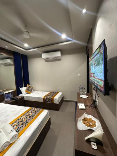 a hotel room with two beds and a flat screen tv at HOTEL PREMIER CHOICE - JUST 50 Meters FROM AJMER SHARIF DARGAH in Ajmer