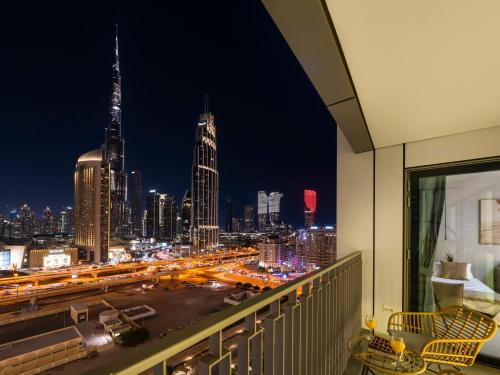 a view of a city skyline at night from a balcony at Premium Two-Bedroom Apartment with Private Balcony & Full Burj Khalifa Views by Al Fannan Holiday Homes in Dubai