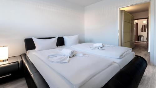 ein großes weißes Bett mit zwei weißen Handtüchern darauf in der Unterkunft Bernsteinbad Koserow - Haus Fünf Elemente Ferienwohnung Feuer in Ostseebad Koserow