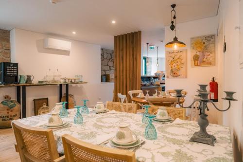 a dining room with a table with blue vases on it at Aquénio do Ouriço in Sernancelhe