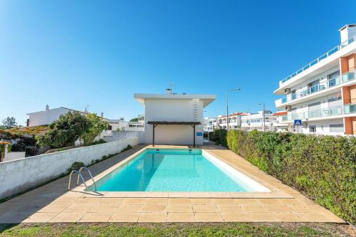 a swimming pool in front of a building at Host Wise - Serene Spacious House - Swimming Pool & Garden in Olhos de Água