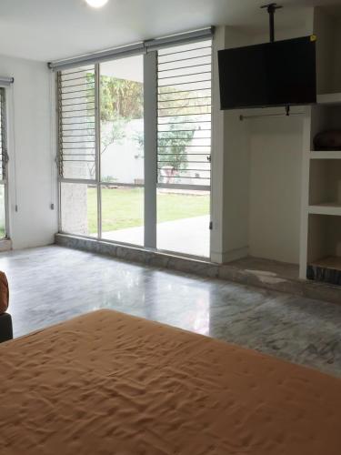 a living room with a large window and a flat screen tv at Estancia Monraz in Guadalajara