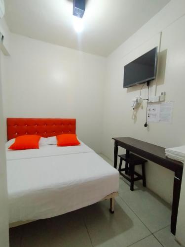 a bedroom with a bed and a desk and a television at Lodge88 ( l l ) in Ranau