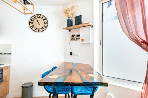 a table and chairs in a small room with a clock at Il Était Une Fois - GAP Chambre romantique & SPA in Gap