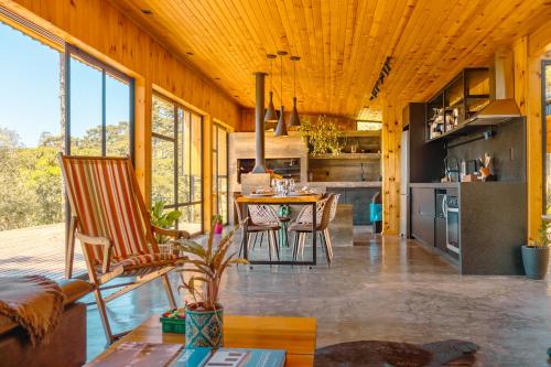 a kitchen and living room with a table and chairs at Cabana na Serra Lareira e Vista Deslumbrante in Rio Rufino