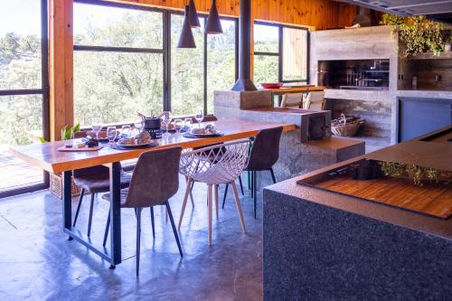 a kitchen with a large wooden table and chairs at Cabana na Serra Lareira e Vista Deslumbrante in Rio Rufino