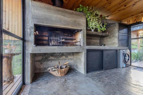 an outdoor kitchen with a stone fireplace in a house at Cabana na Serra Lareira e Vista Deslumbrante in Rio Rufino