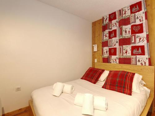 a bedroom with a bed with white sheets and red pillows at Appartement rénové proche des pistes - 4 pers, balcon, casier à skis - FR-1-575-211 in Courchevel