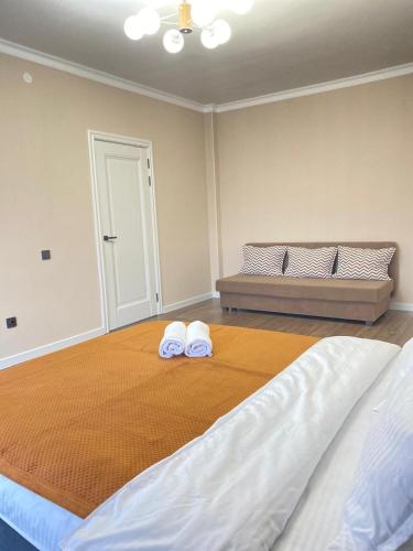 a bedroom with a bed with two towels on it at Б241 Нурлы-жол in Promyshlennyy