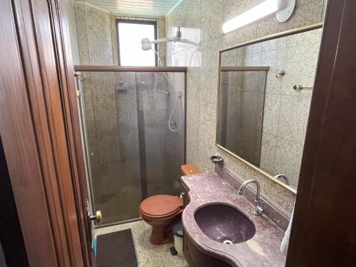 a bathroom with a toilet and a sink and a shower at Condomínio Bariloche in Salinópolis