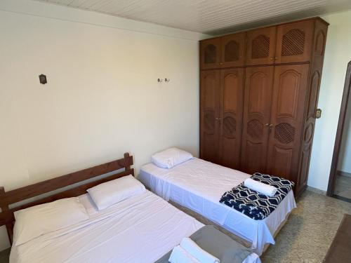 two beds in a small room with a door at Condomínio Bariloche in Salinópolis