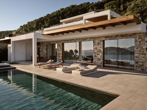 a villa with a swimming pool and a house at Thesan Villas in Marathias