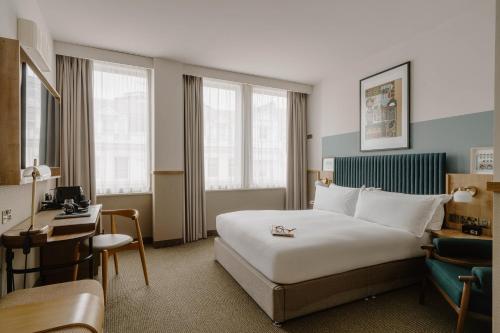 a hotel room with a bed and a desk at Club Quarters Hotel St Paul's, London in London