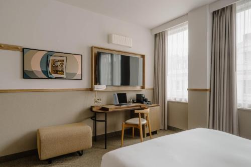 a hotel room with a bed and a desk with a computer at Club Quarters Hotel St Paul's, London in London