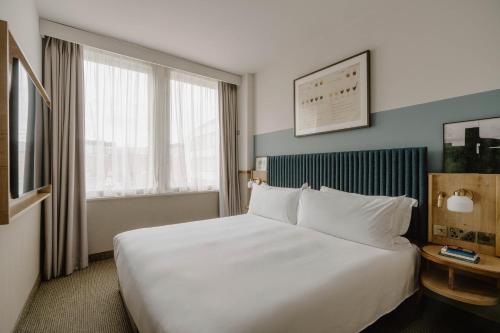 a hotel room with a large bed and a window at Club Quarters Hotel St Paul's, London in London