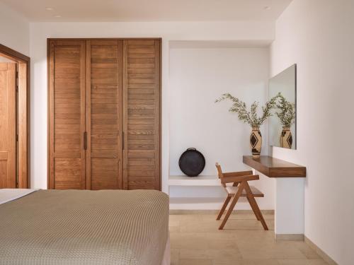 a bedroom with a wooden door and a desk at Thesan Villas in Marathias
