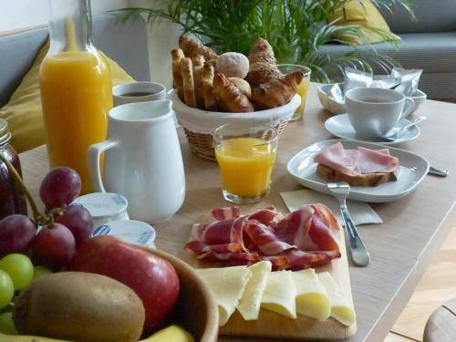 a table with a breakfast of cheese and fruit at Casa Mathilda in Barcelona