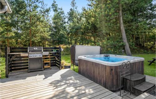 a hot tub and a grill on a deck at Four-Bedroom Holiday Home In Hojby in Højby