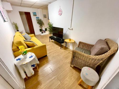 a living room with a yellow couch and chairs at Dotan's Boutique Guesthouse - By The Beach! in Tel Aviv