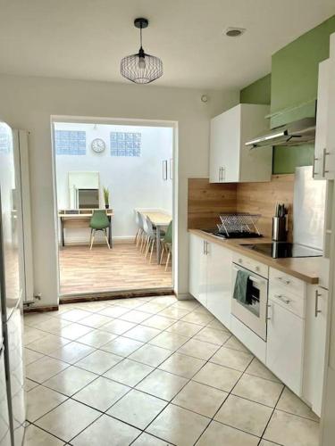 une cuisine avec une table et une salle à manger dans l'établissement Maison 5 chambres idéal famille et groupe, à Anzin