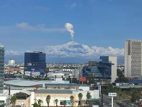 a view of a city with a smoke stack at La Quinta by Wyndham Puebla Palmas Angelopolis in Puebla
