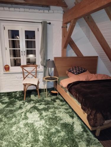 a bedroom with a bed and a chair at Ferienwohnung im Neubauernweg 3 in Hoppegarten
